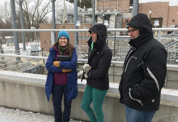 Terri Habig, Sarah Gothe and Josh Crawford are still smiling despite 22-degree wind at Goshen’s Wet Weather Detention Center. The facility stores stormwater during flood events, preventing overflow of untreated water.