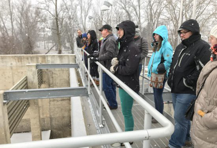 MAEE students look over a tank that can keep 2.5 million gallons of stormwater out of the Elkhart River until it can be treated.