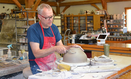 Man carving into Pottery clay