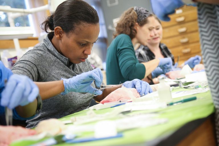 Students practicing nursing skills in class