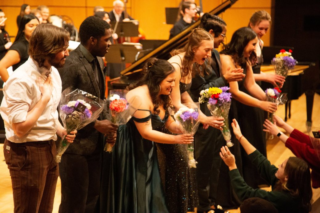 performers accepting bouquets while on stage
