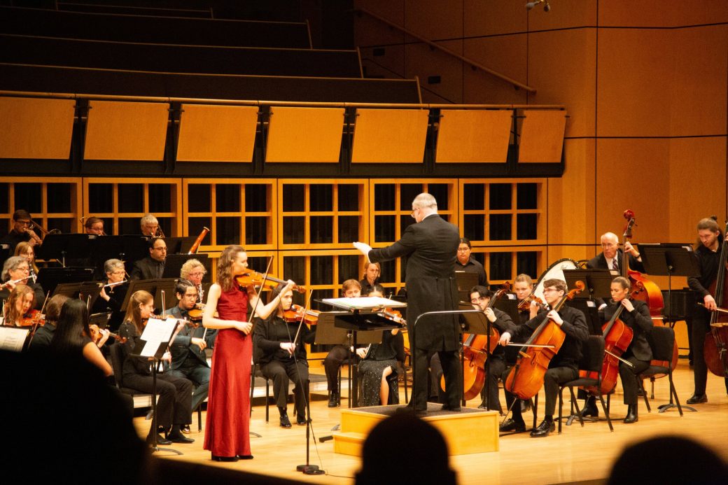 solo violinist plays in front of orchestra