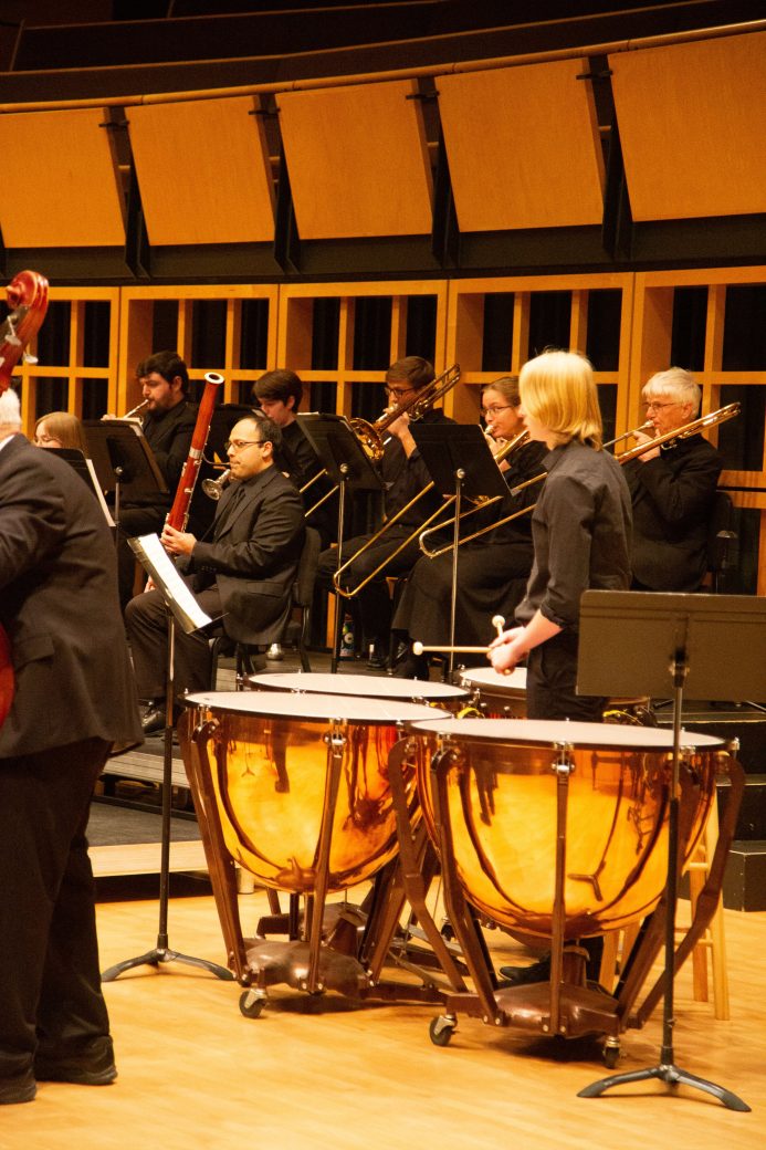 male student plays large drums