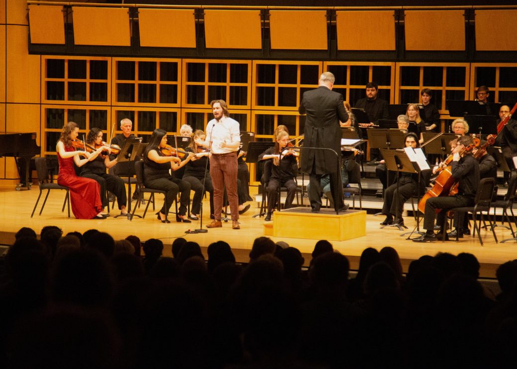 solo performer singing in front of orchestra