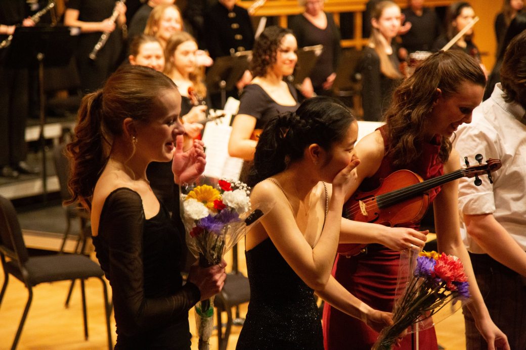 close up of performers accepting bouquets while on stage