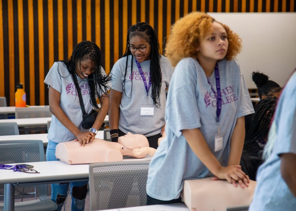 summer camp students practice cpr on dummies