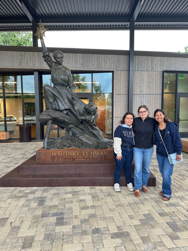 Students standing with a statue