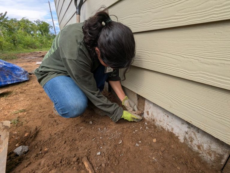 Student working on the side of a house