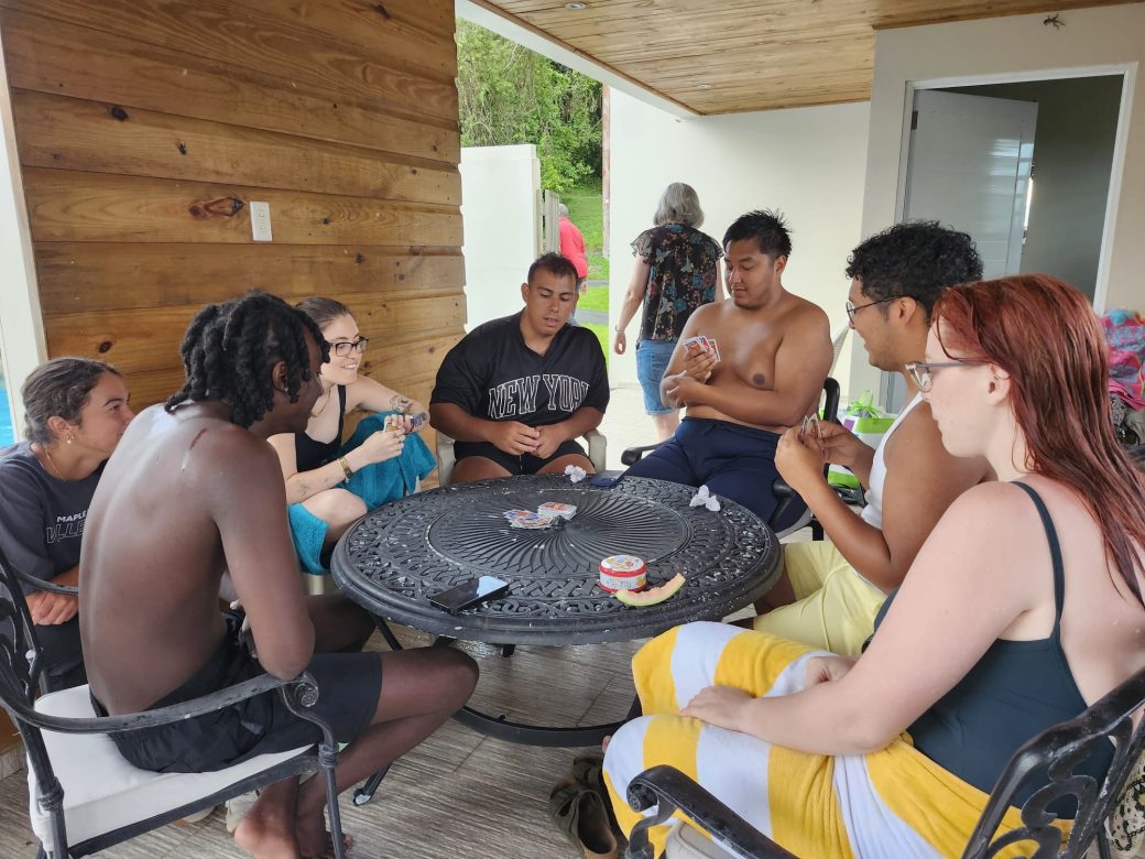 students gathered around a table playing cards