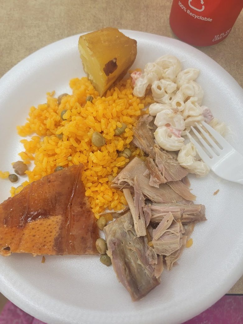 A plate of lechon, arroz con habichuelas, batata frita, and macaroni salad