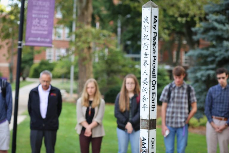 Students praying around a 'peace pole'