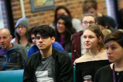 Students watching presentations at the academic symposium in a Goshen College classroom