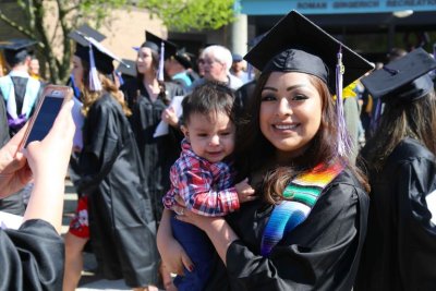 Graduate holding baby on Commencement