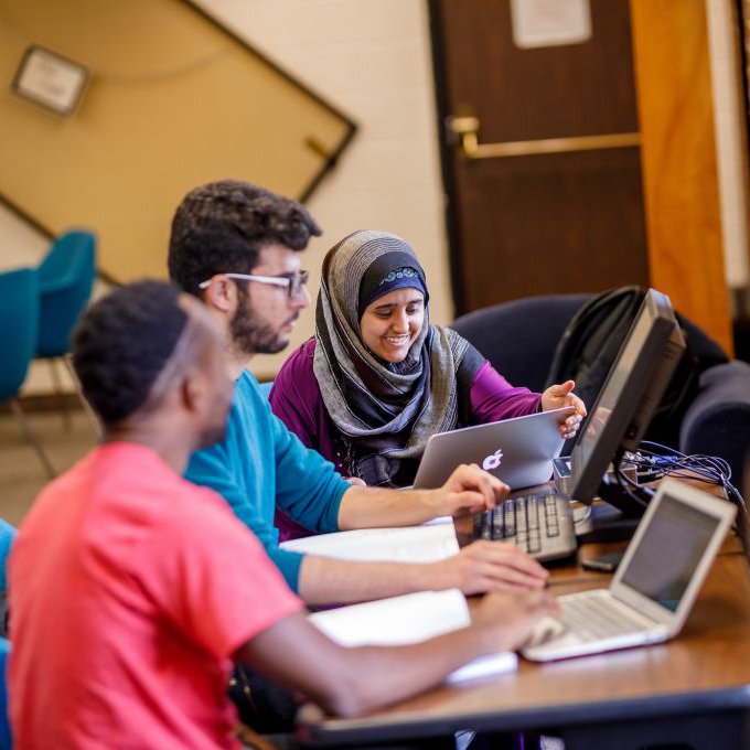 mixed ethnicity students sitting around computer