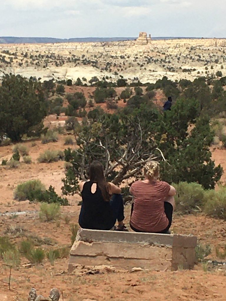 two students sit facing away from camera in US Southwest desert