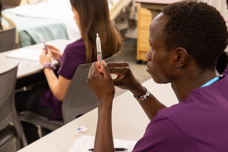 Student using syringe for nursing class