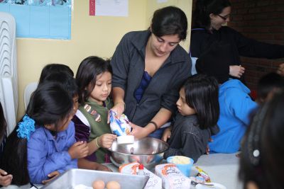 Woman helping kids bake