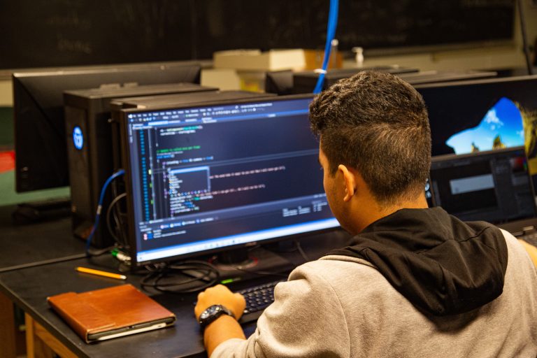 A student codes on a laptop