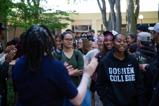 Students excitedly proceeding through a gauntlet of people clapping
