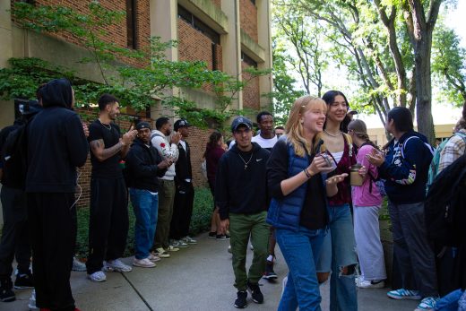 Students excitedly proceeding through a gauntlet of people clapping