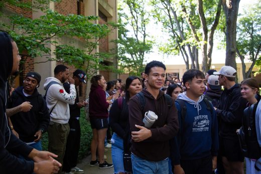 Students excitedly proceeding through a gauntlet of people clapping