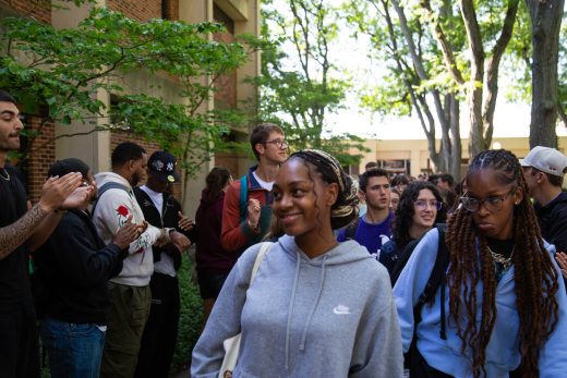 Students excitedly proceeding through a gauntlet of people clapping
