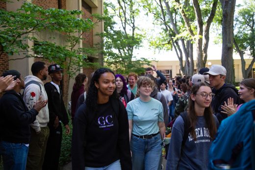 Students excitedly proceeding through a gauntlet of people clapping