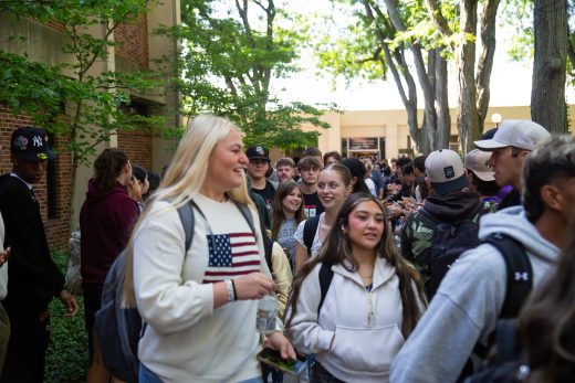 Students excitedly proceeding through a gauntlet of people clapping