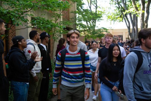 Students excitedly proceeding through a gauntlet of people clapping