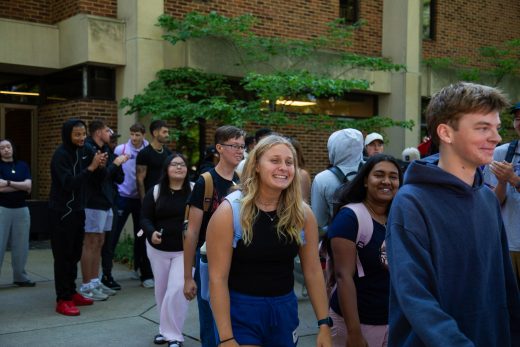 Students excitedly proceeding through a gauntlet of people clapping