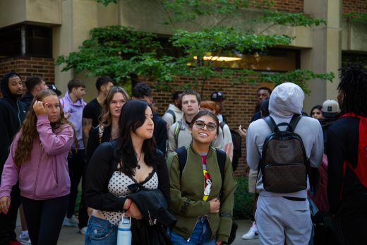 Students excitedly proceeding through a gauntlet of people clapping