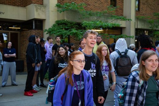 Students excitedly proceeding through a gauntlet of people clapping