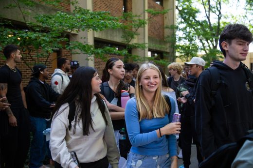 Students excitedly proceeding through a gauntlet of people clapping