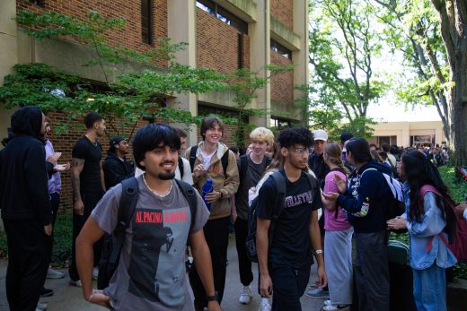 Students excitedly proceeding through a gauntlet of people clapping