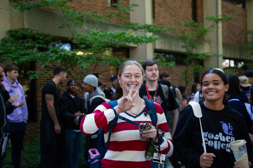 Students excitedly proceeding through a gauntlet of people clapping