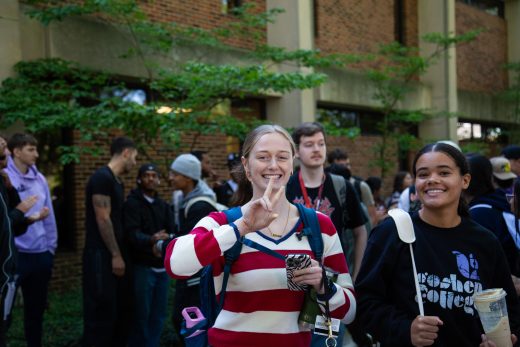 Students excitedly proceeding through a gauntlet of people clapping