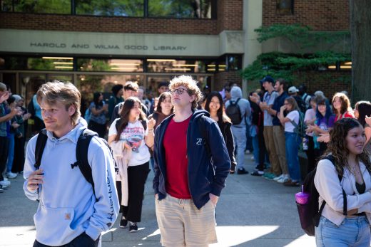 A student stands proudly amidst the applause