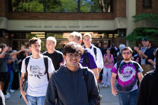 Students excitedly proceeding through a gauntlet of people clapping