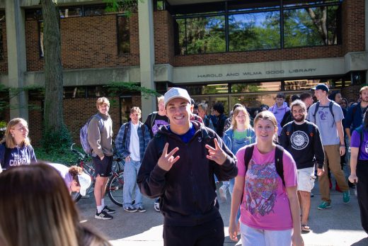 Students excitedly proceeding through a gauntlet of people clapping