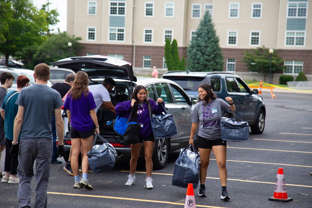 Students carrying items for moving in