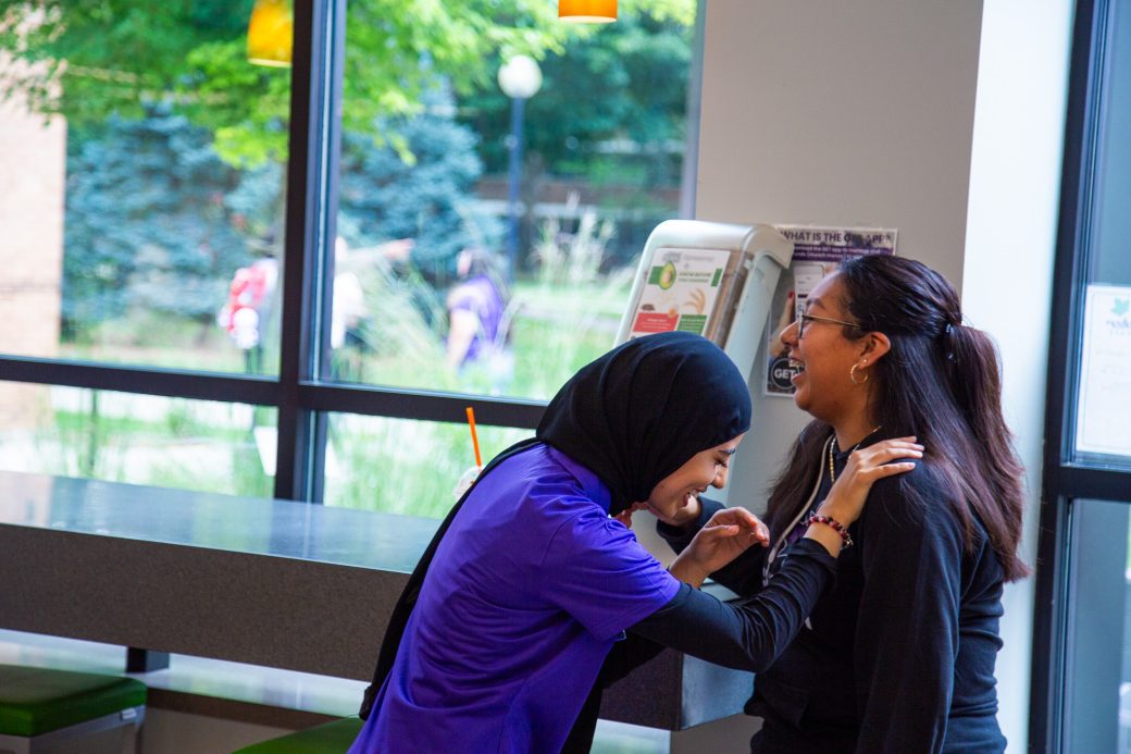 Two students laugh together