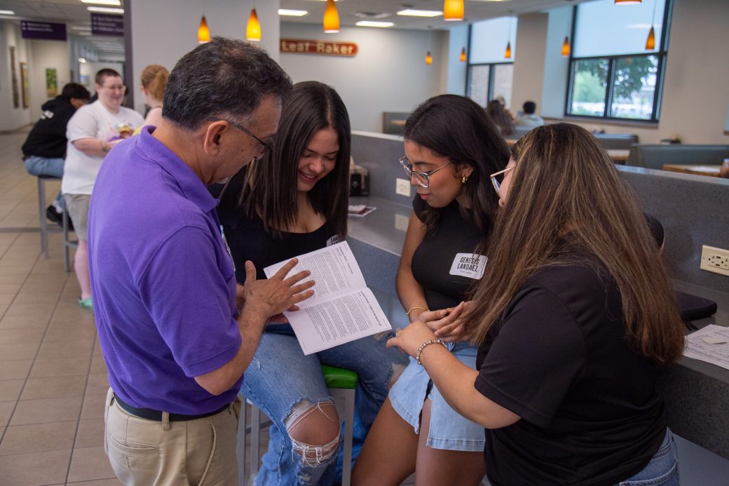 Students gather around a book