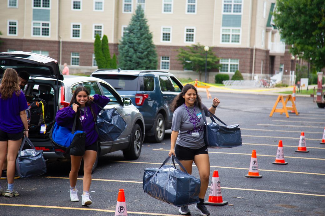 Students smiling and carrying bags