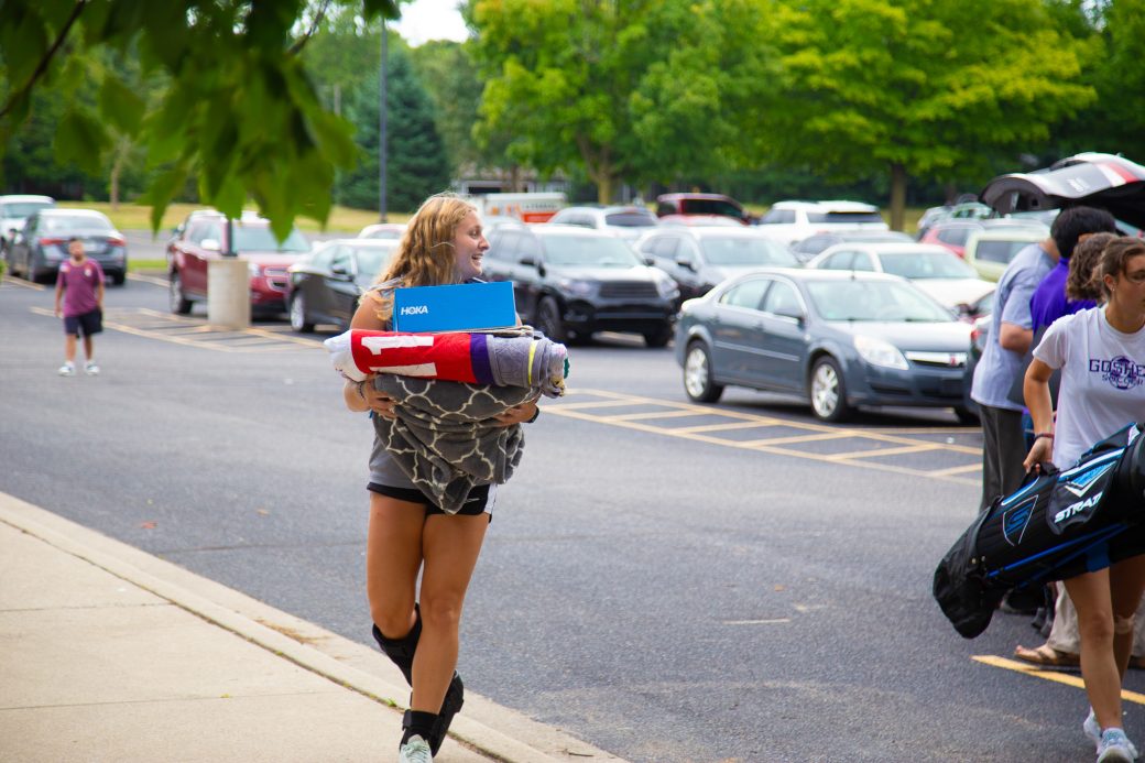 Students carrying items for moving in