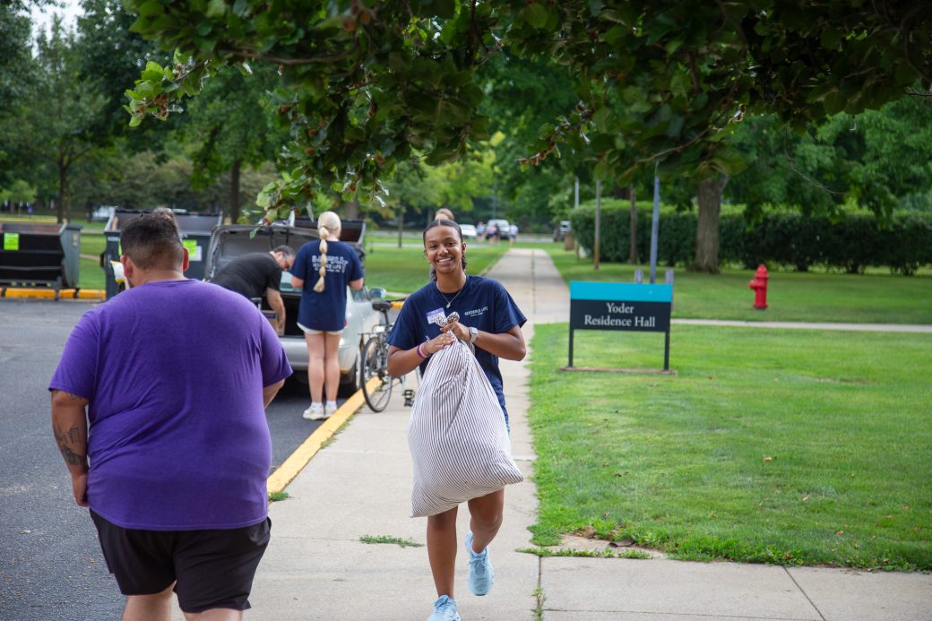 Students carrying items for moving in