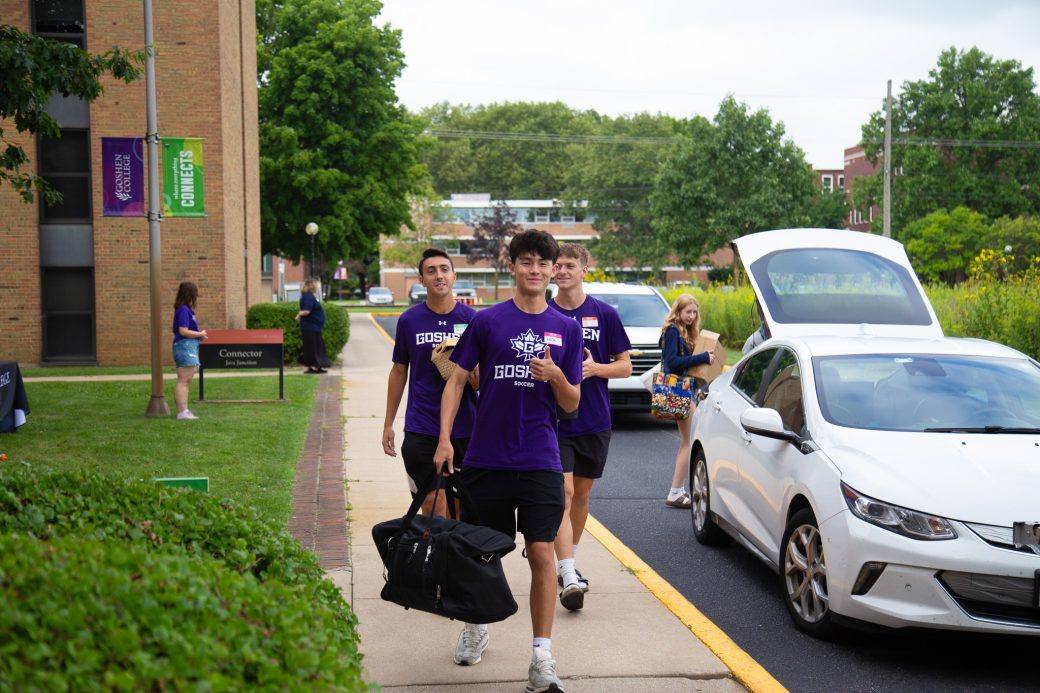 Students carrying items for moving in