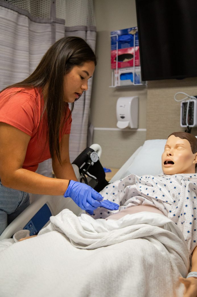 A student assesses a manikin