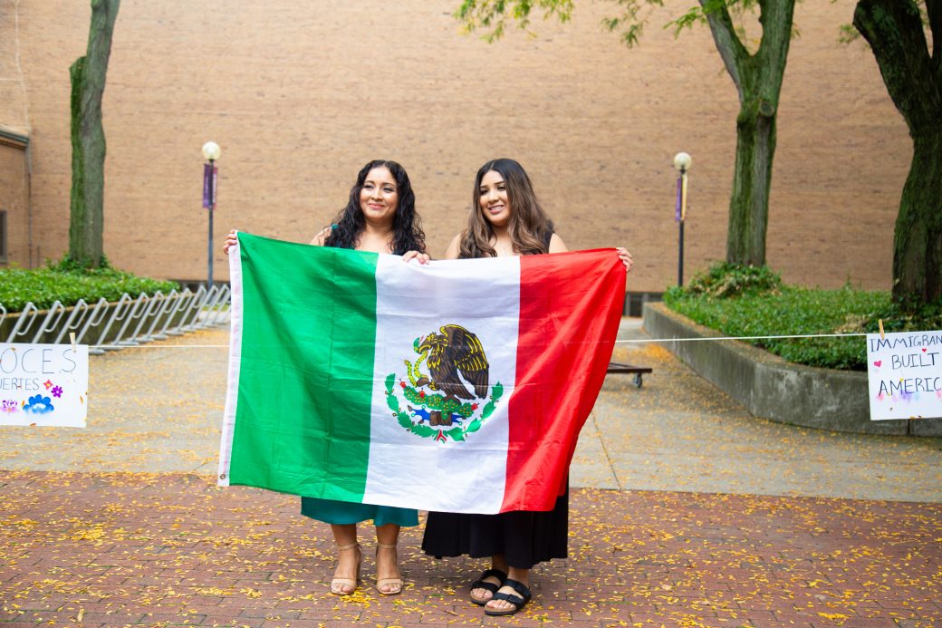 two students holding the Mexican flag