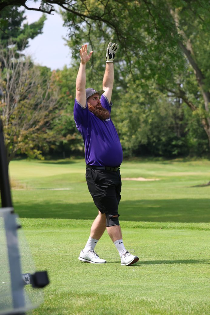 A man celebrates on a golf course