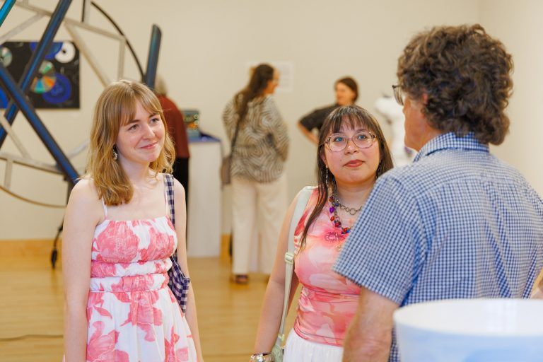 Two students talking to faculty member